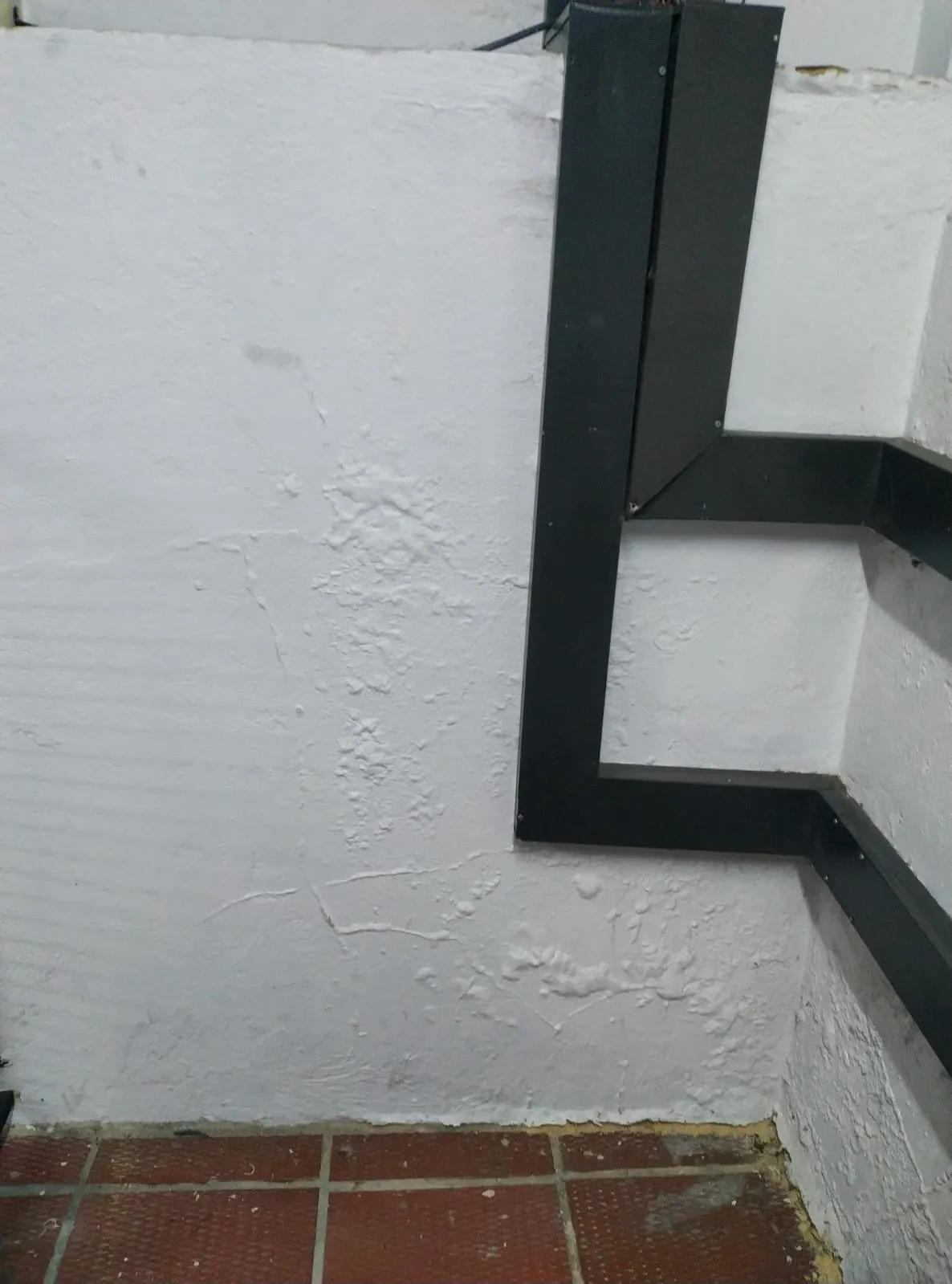 Obra de Avellaneda Constructores: muro resanado y pintado con canaleta metálica